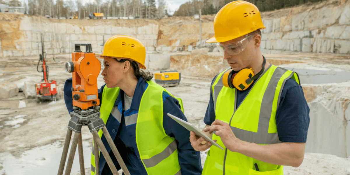 Workers using surveying equipment